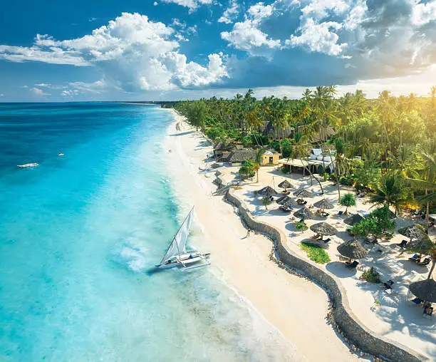 Beach chairs on Zanzibar shoreline at sunset
